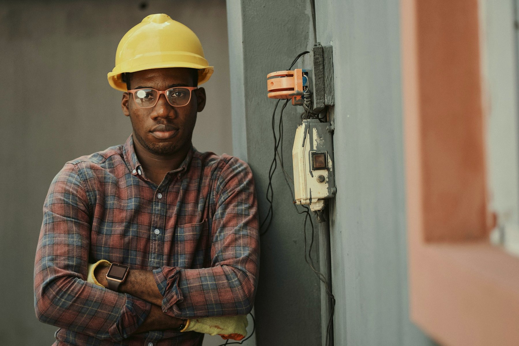 A tradesman in a hard hat, arms crossed, looking straight at the camera